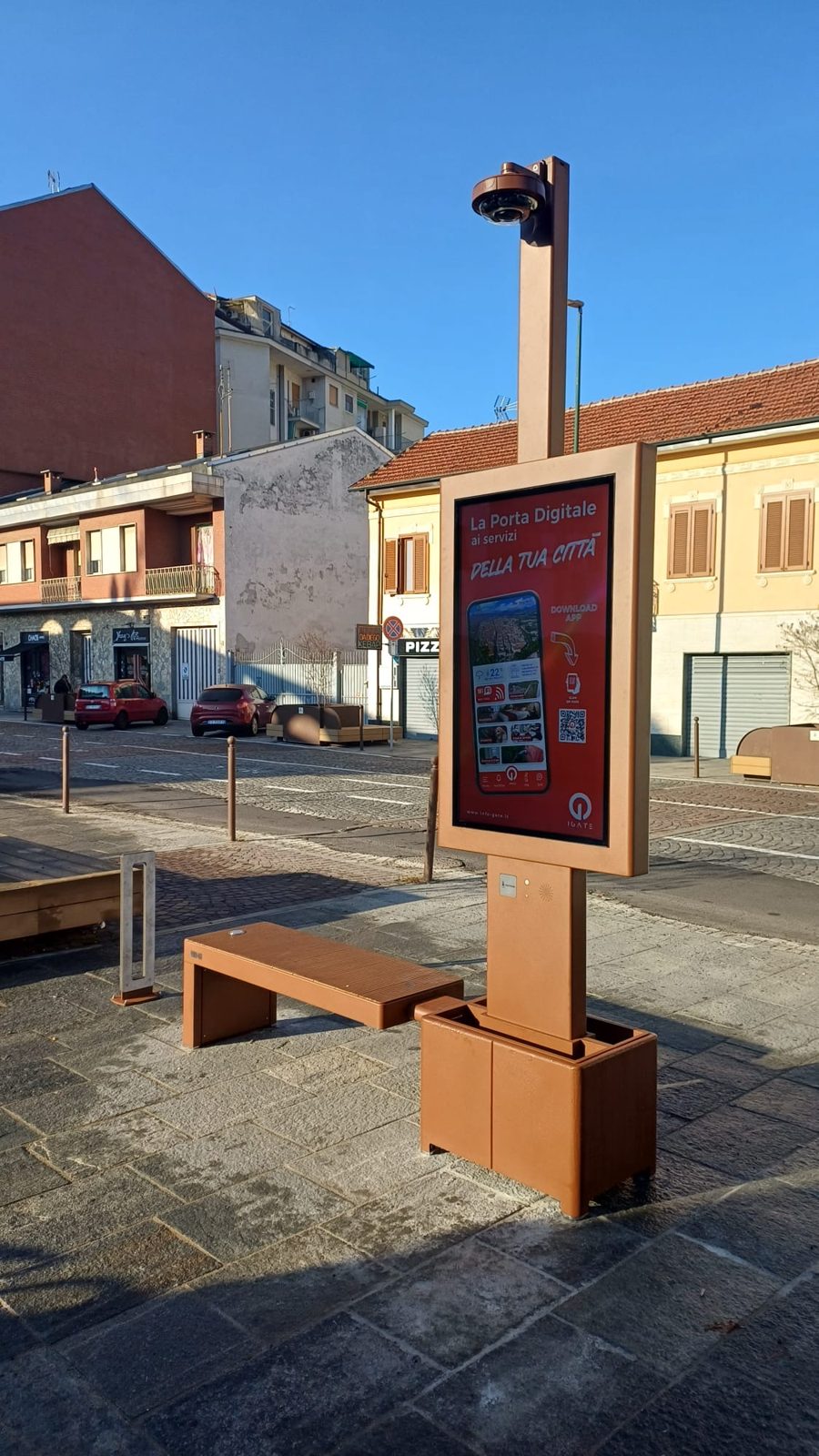 Isola digitale i-Gate con monitor e seduta in una piazza al sole